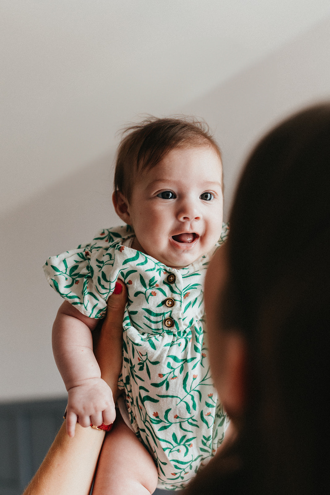 bébé sourit à sa maman qui le porte